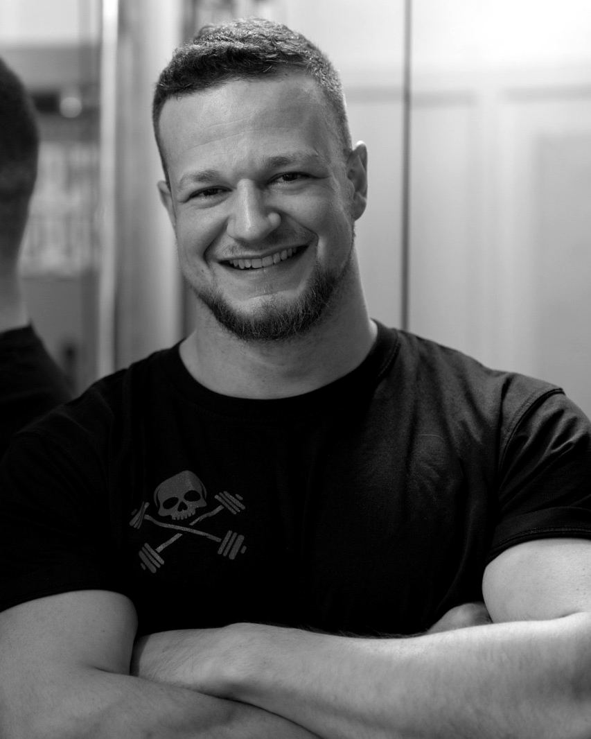 Tom, Inhaber von Tom’s Powerhouse, lachend mit verschränkten Armen im Studio